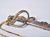 a very old sword with a gold handle on a white surface