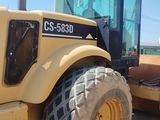a picture of a yellow tractor parked on the side of the road