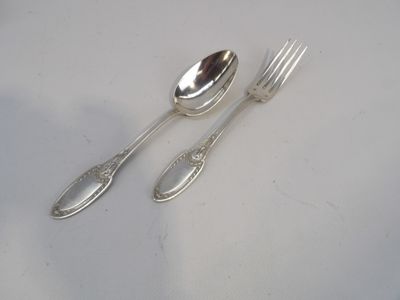 deux cuillères et une fourchette en argent sur une table
