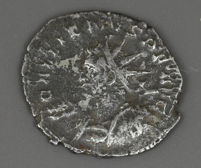 une vieille pièce d'argent posée sur une surface grise avec un fond blanc