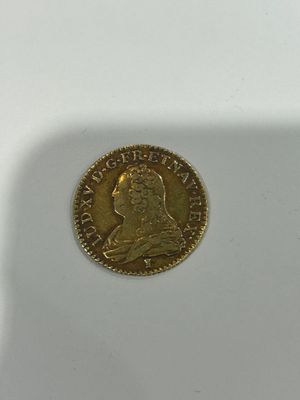 a close up of a coin on a white surface with a shadow