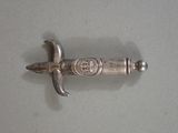 a silver object on a table with a knife in it