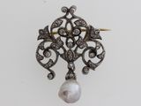a close up of a pearl and diamond pendant on a white background