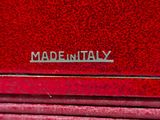 a close up of a red suitcase with the words made in italy written on it