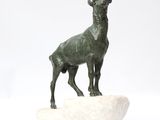 statue of a goat on a rock on a white background