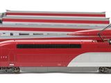 four red and white trains sitting next to each other on a white surface
