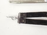 two different types of scissors and a pen on a white surface