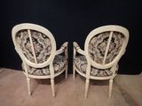 two white chairs with floral upholstered upholstered cushions