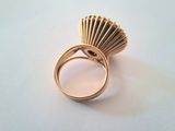 an image of a gold ring with a shell on top of it