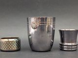 three silver vases sitting next to each other on a table