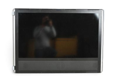 un homme en train de se prendre en photo dans le reflet d'un écran de télévision