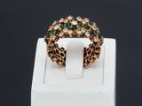 a close up of a gold ring with green and white stones