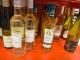 several bottles of wine are lined up on a shelf in a store