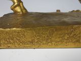 bronze statue of a man holding a bird on a rock