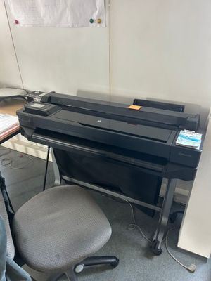 un bureau avec une imprimante et une chaise dans un coin