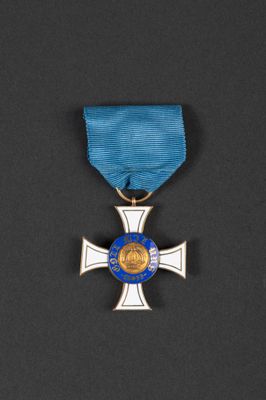 a silver cross with a blue ribbon on a black background