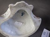 a white vase with a tag on it sitting on a table