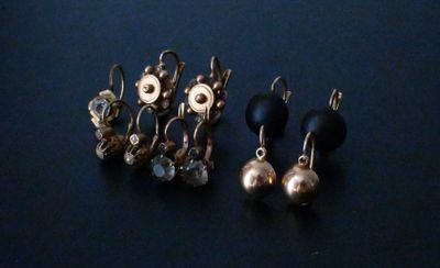 deux paires de boucles d'oreilles sont posées sur une surface bleue