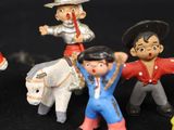 several toy figurines of different characters are posed on a black surface