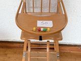 une chaise haute en bois avec une pancarte fixée à l'arrière