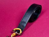 a close up of a black leather belt with a gold buckle