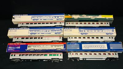 Plusieurs petits trains sont alignés les uns à côté des autres sur une surface noire