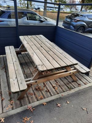 une table de pique-nique posée sur une plate-forme en bois dans un parking