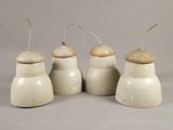 trois pots en céramique blanche avec des couvercles en bois et un fil métallique sur le dessus