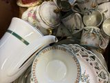 a box full of tea cups and saucers