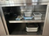 a stainless steel cabinet with plastic containers on top of it