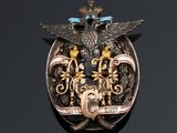 an image of a silver and gold broochle with a bird on it