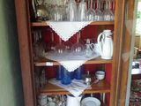 une grande armoire en bois sur laquelle sont disposés de nombreux plats et verres