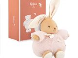 une petite peluche assise à côté d'une boîte