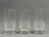 trois vases en verre transparent posés les uns à côté des autres sur une surface grise