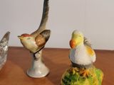 three figurines of birds sitting on top of a wooden table