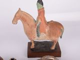 a figurine of a man riding a horse next to other items
