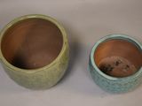 two green vases sitting next to each other on a table