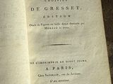 un livre ouvert posé par terre sur un fond noir