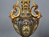 a vase that is sitting on a stand on a gray surface