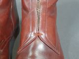 pair of red leather boots with zippers on the side of them