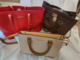 trois sacs à main de couleurs différentes posés sur un drap blanc