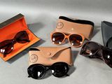 trois paires de lunettes de soleil dans un étui et une paire de lunettes de soleil dans une boîte