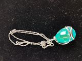 a close up of a necklace on a black surface with a silver chain