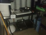 several plates and pans are stacked on a shelf in a kitchen
