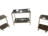 trois chariots en métal et en verre et une étagère en verre sur fond blanc