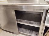 a stainless steel cabinet with a door open in a kitchen