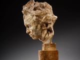 a marble head of a man on a wooden base