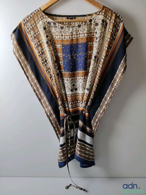 a close up of a shawl hanging on a hanger on a wall