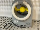 a small fan that is on a shelf in a room