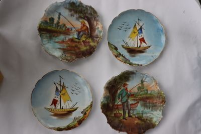 quatre assiettes décoratives ornées de bateaux peints, posées sur une table